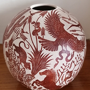 Red design carved onto white clay pottery 